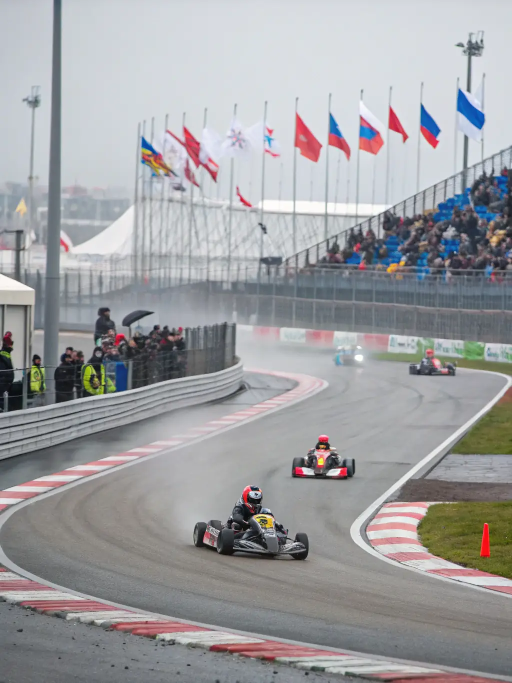 A vibrant photograph capturing the excitement of a regional karting competition organized by AK DU CENTRE, showcasing young participants racing on a well-maintained track.